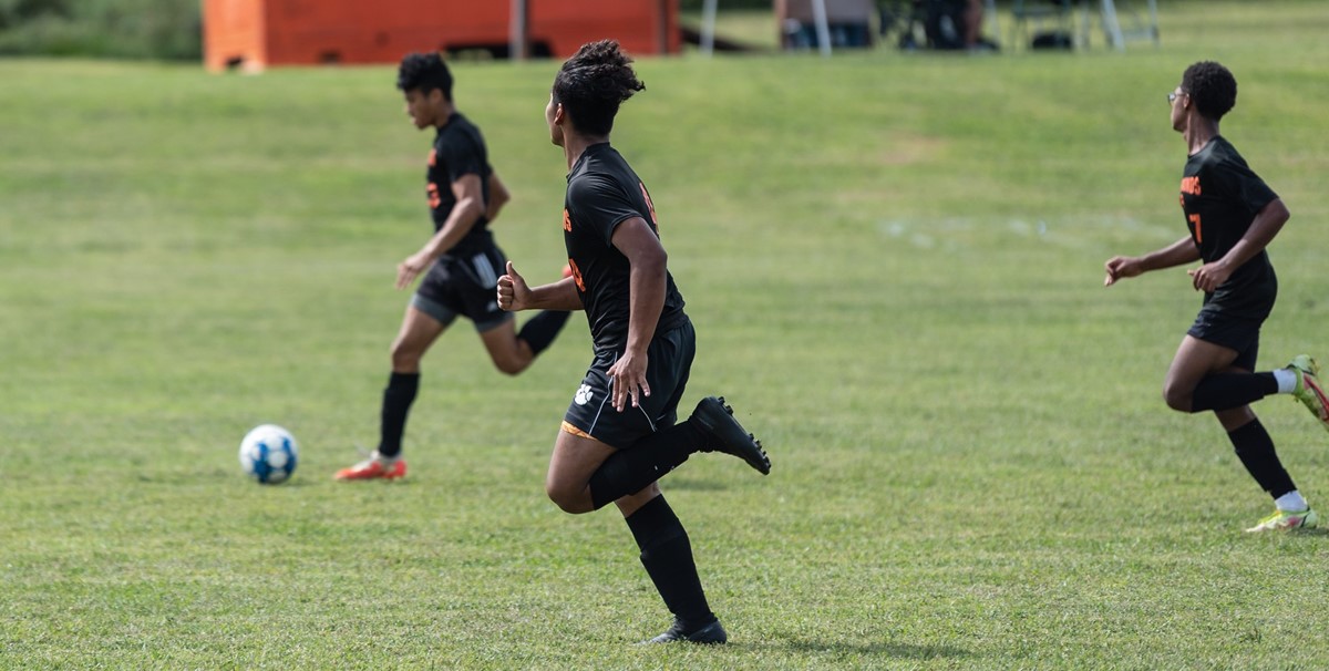 Boys soccer players dribbling ball